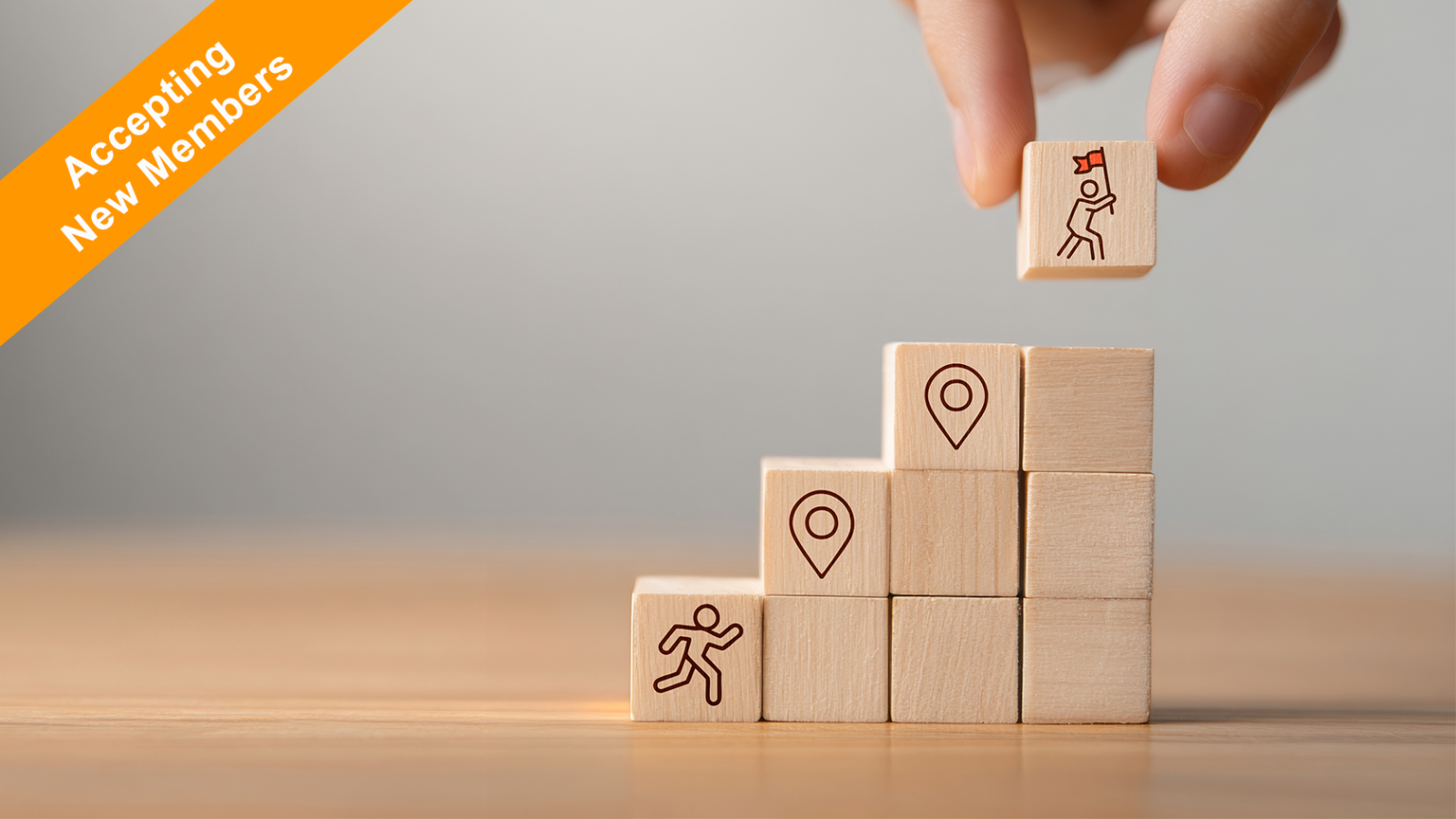 Wooden blocks arranged as steps with icons of a runner, location pins, and a climber reaching a flag, with an orange “Accepting New Members” banner in the corner
