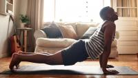 Shot of a young man practising yoga at home during the day